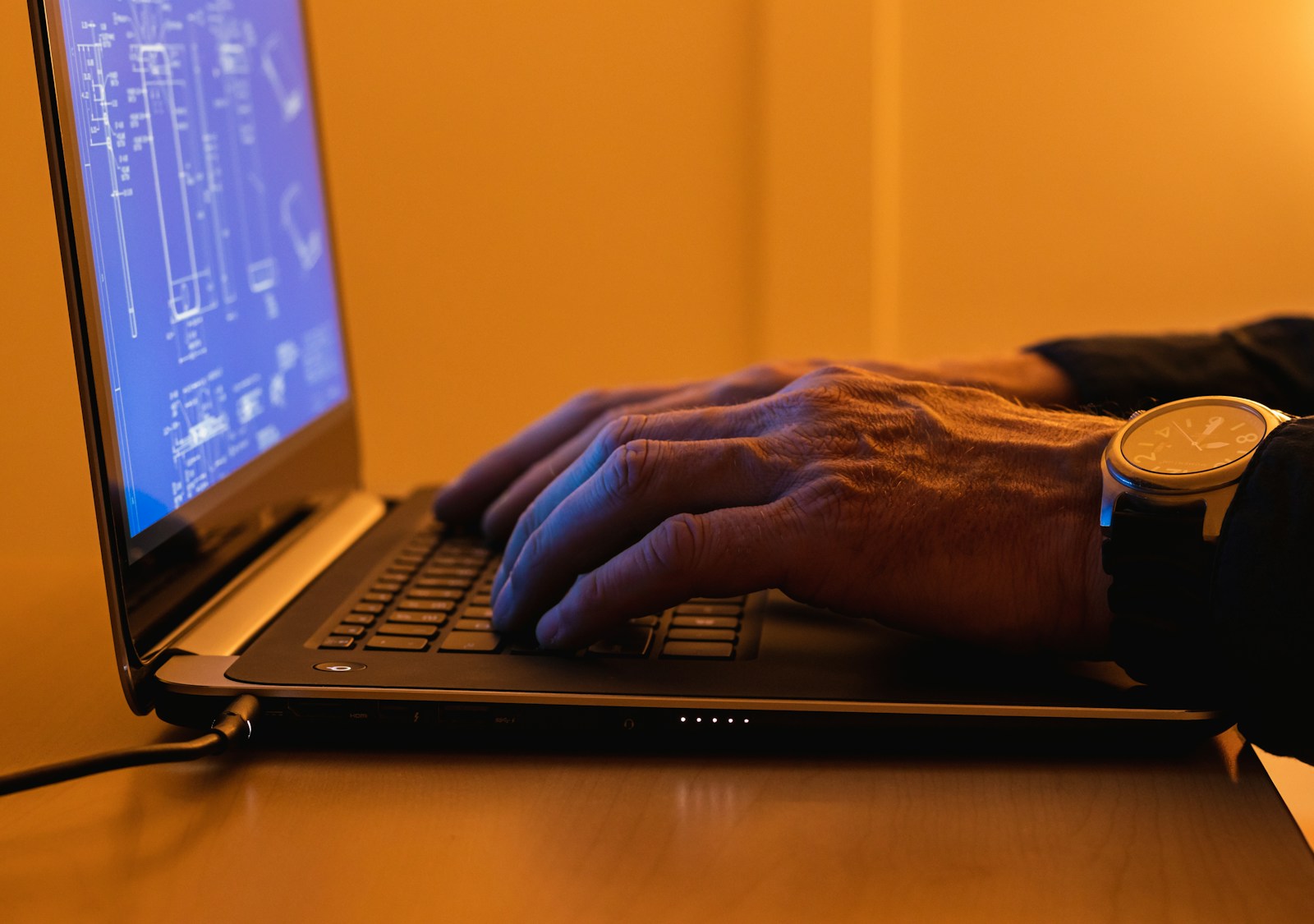 a person using a laptop computer on a desk, cyber liability